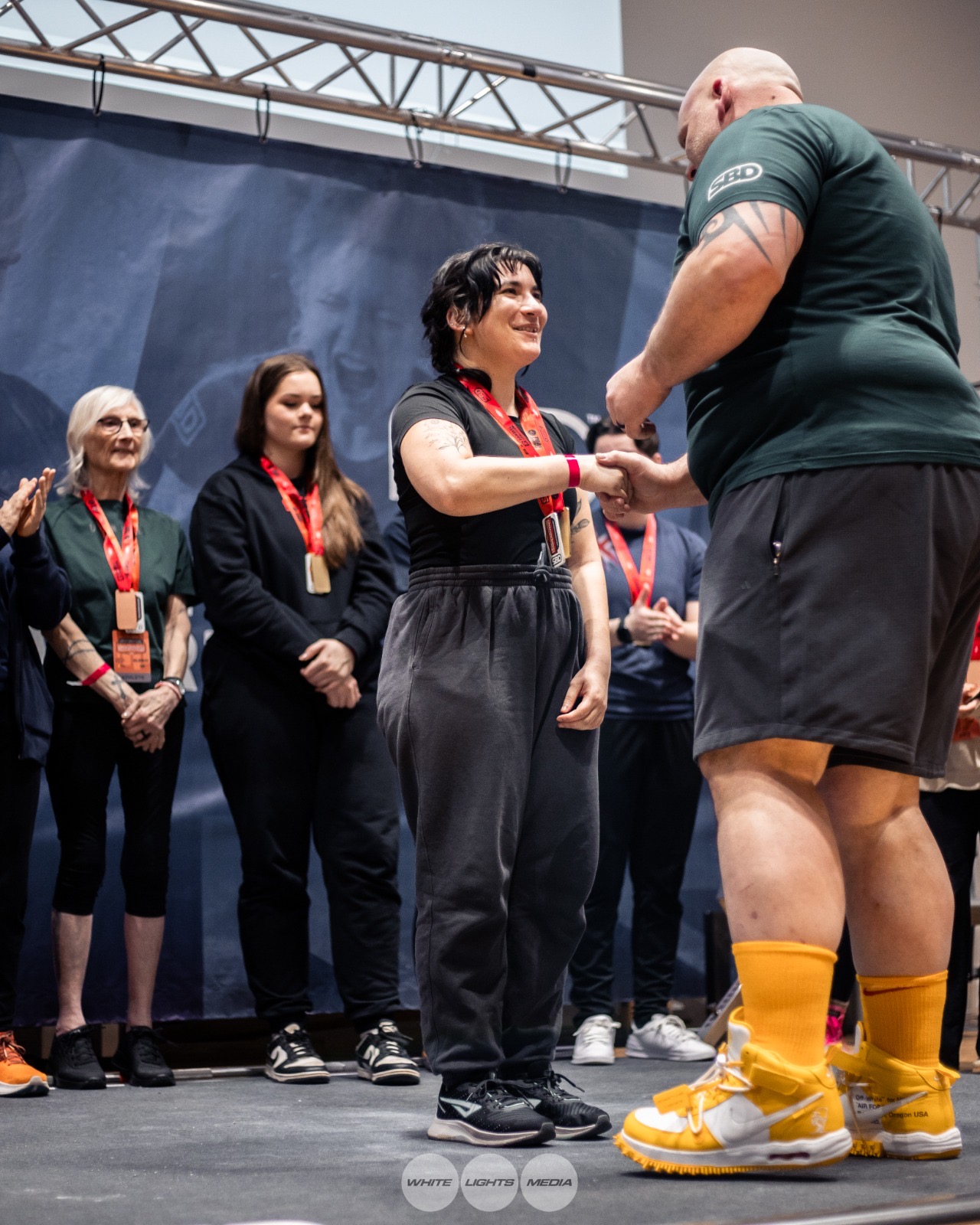 Sara shaking hands as she receives her medal