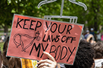 Someone holding up a sign at a protest that says 