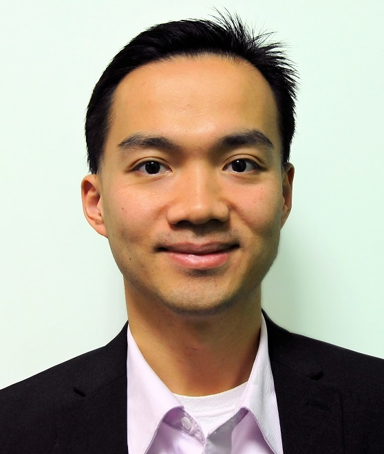 Zion Tse smiling at the camera, wearing a white shirt and black blazer