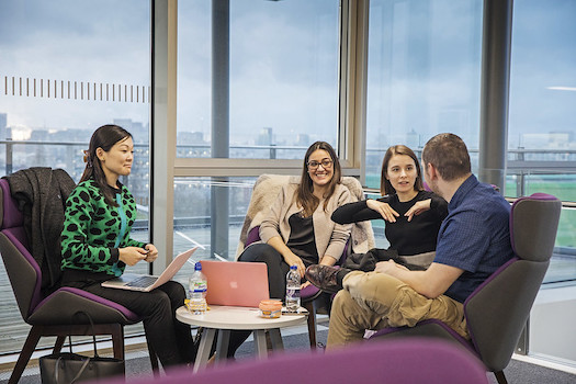 Four postgraduate students talking in the Graduate Centre