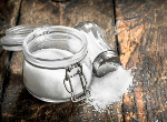 Salt shaker and pot on wooden table.Credit:iStock.com.