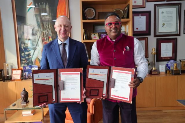 Professor Colin Bailey holding signed Memorandum of Understanding