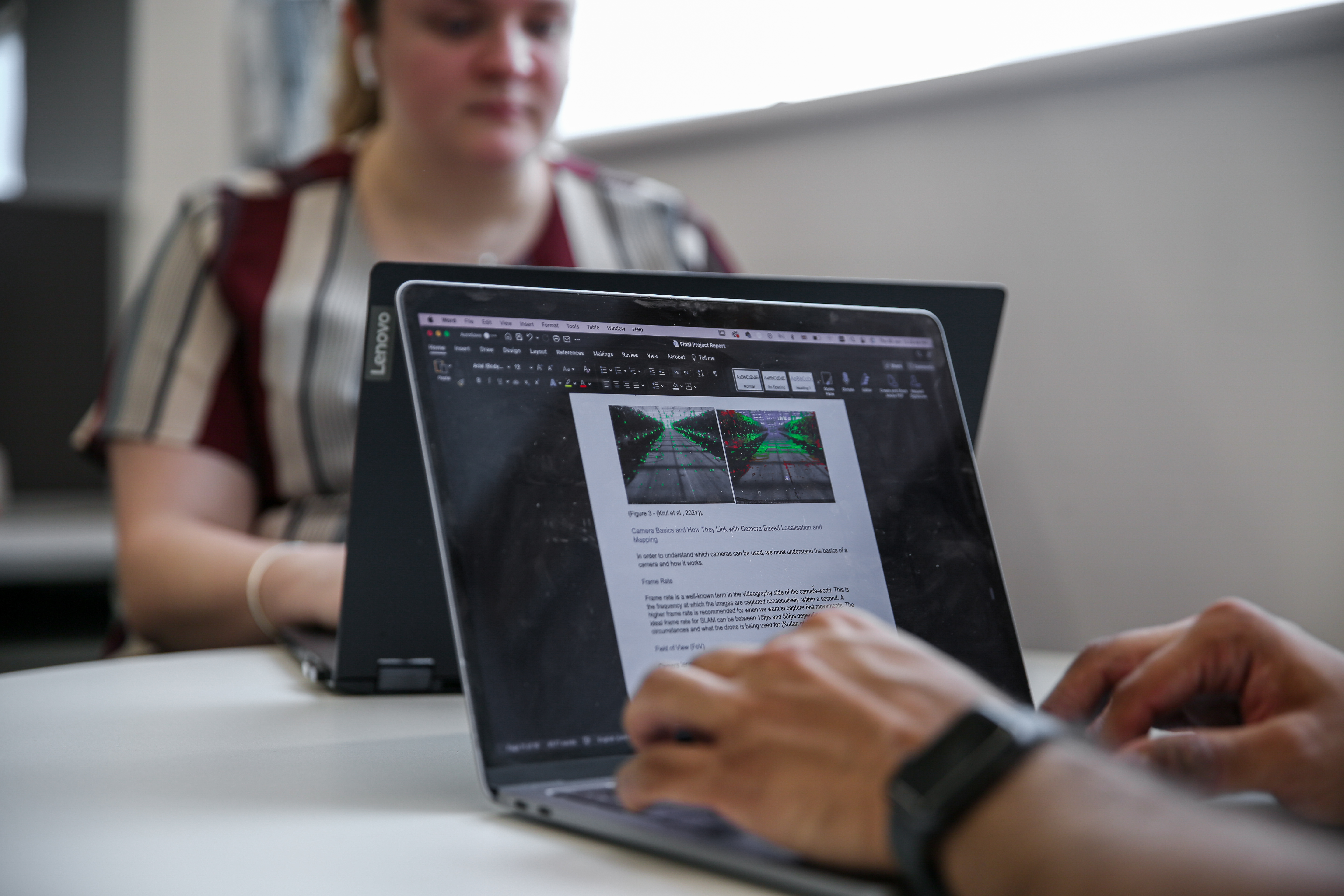 Image shows students/researchers wearing headphones and conducting informal study on their laptop computers.