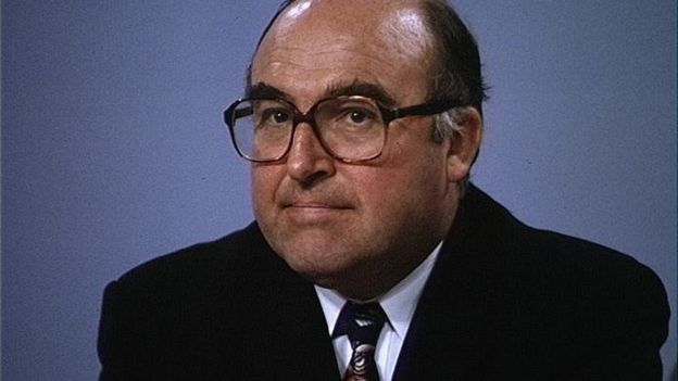 John Smith photographed in TV studio against a blue background