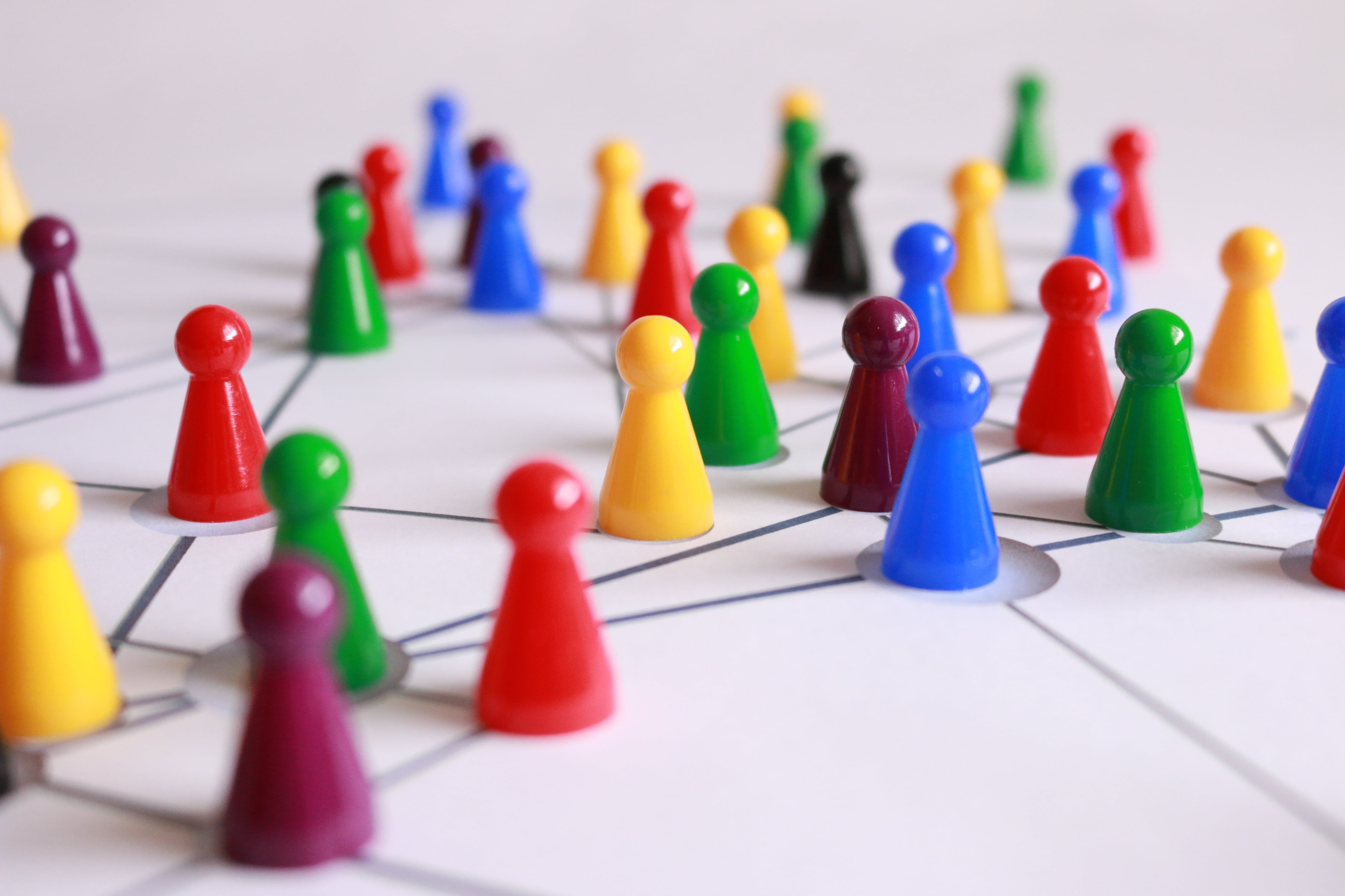 A photo of multi-coloured pawns on a white table