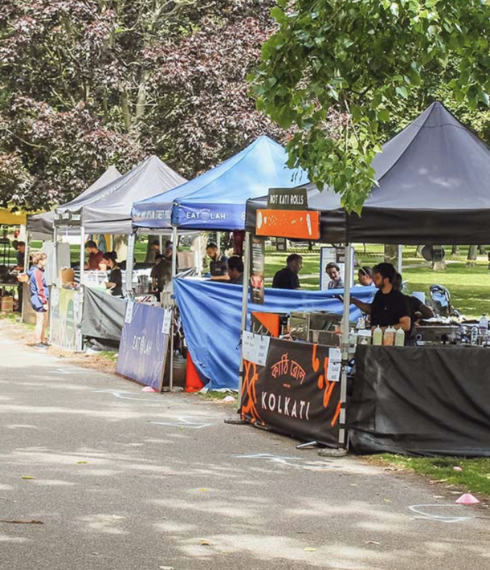 A photo of food stands in a park.