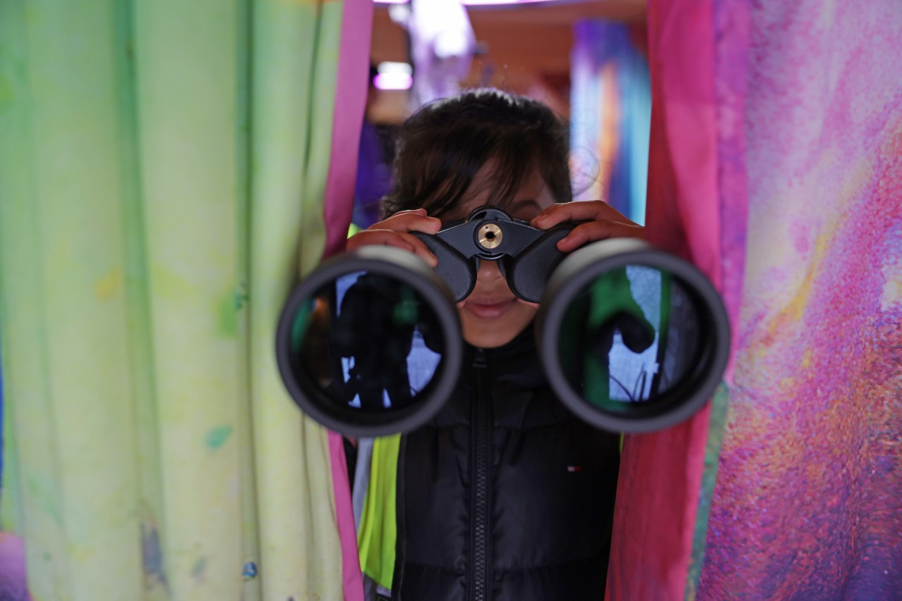A child using binoculars on board moon palace bus