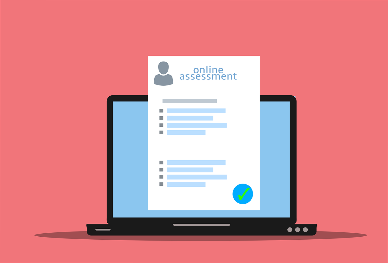 A laptop with a piece of paper in front of it saying online assessment