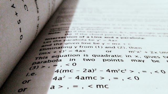 An open textbook displaying mathematical formulas
