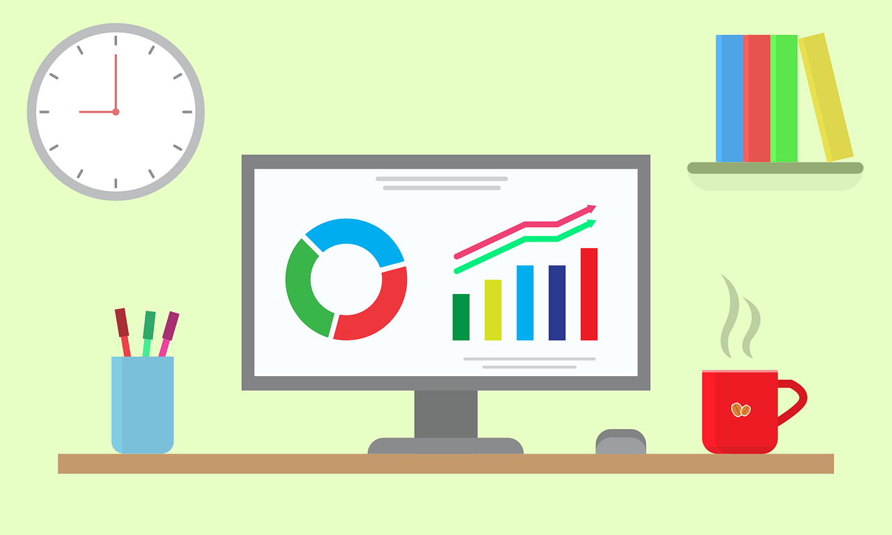 Image of a computer screen on a desk with charts, a cup and pens holder on the desk and a clock and a bookshelf on the wall. Image by Shafin Al Asad Protic from Pixabay