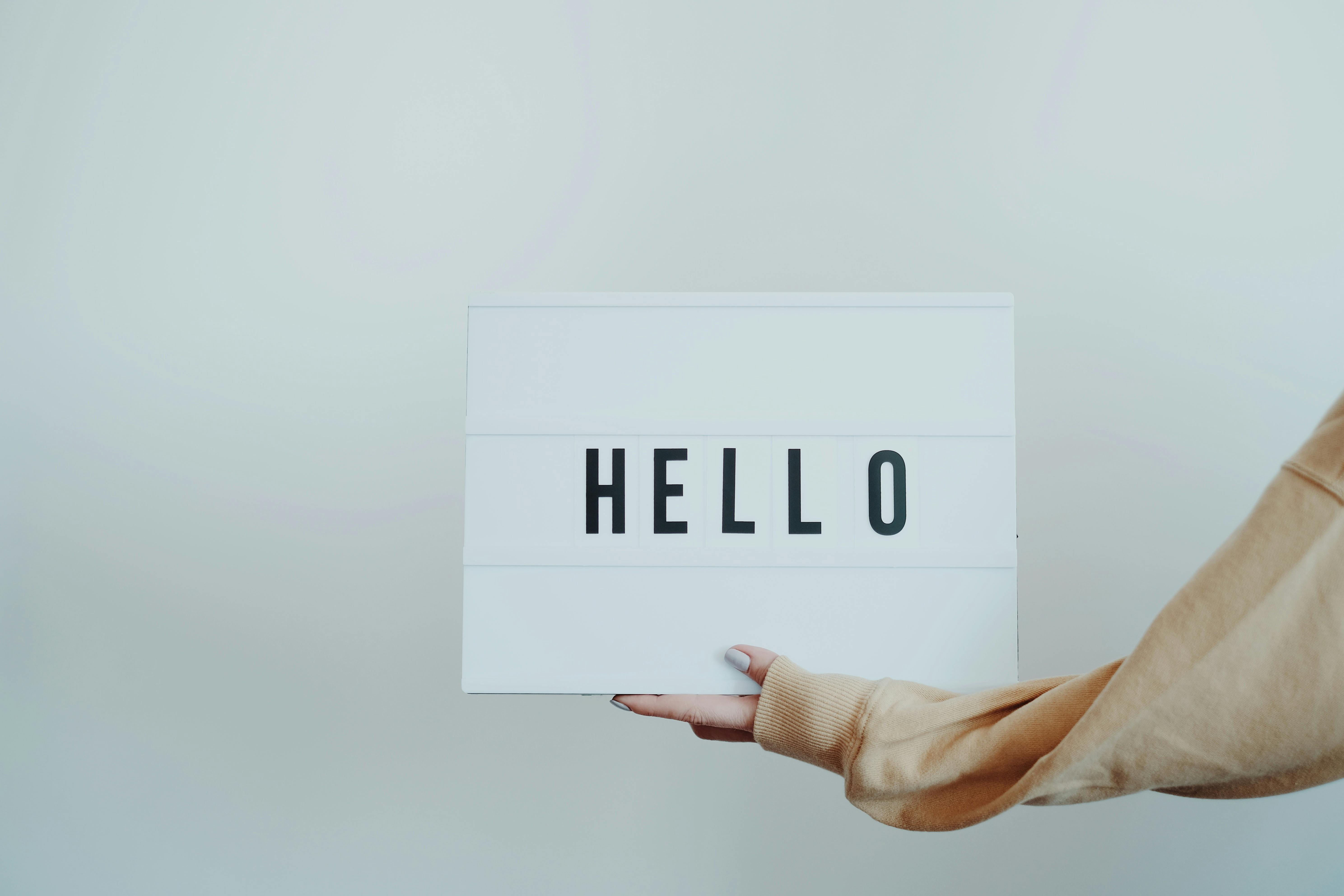 Person holding a lightboard with the word Hello on it